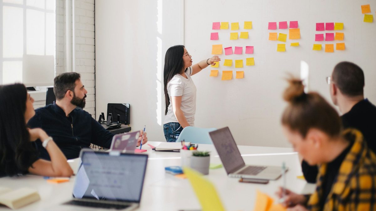 Come scegliere il CRM giusto Team in riunione che mappa processi e requisiti con post-it su una parete prima di scegliere il CRM