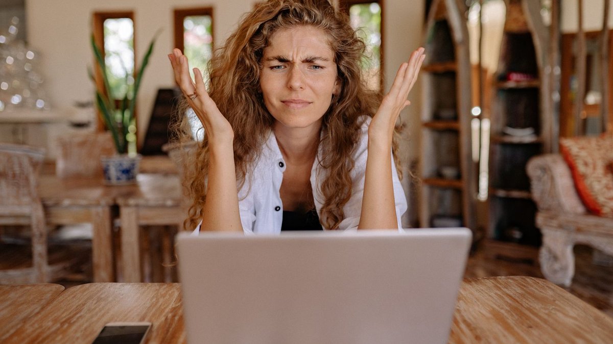 Microsoft Clarity: guida completa allo strumento gratuito di heatmap 3 Donna frustrata davanti al laptop con le mani alzate, come un utente che fa rage click su un pulsante che non risponde